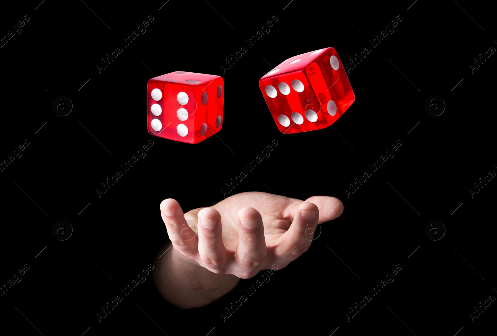 Image of Man throwing red dice on black background, closeup