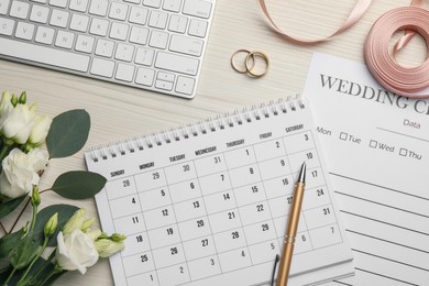 Photo of Flat lay composition with Wedding items and calendar on white wooden table