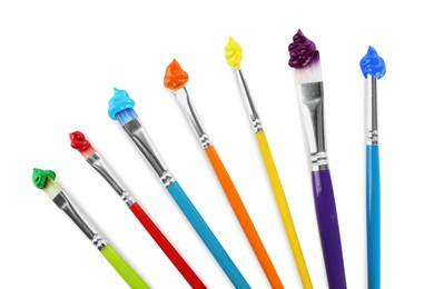 Photo of Brushes with colorful paints on white background