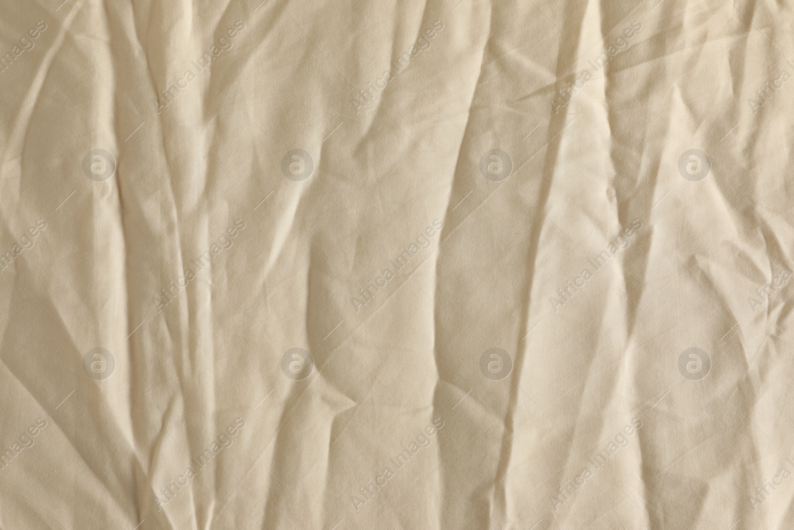 Photo of Crumpled beige fabric as background, top view