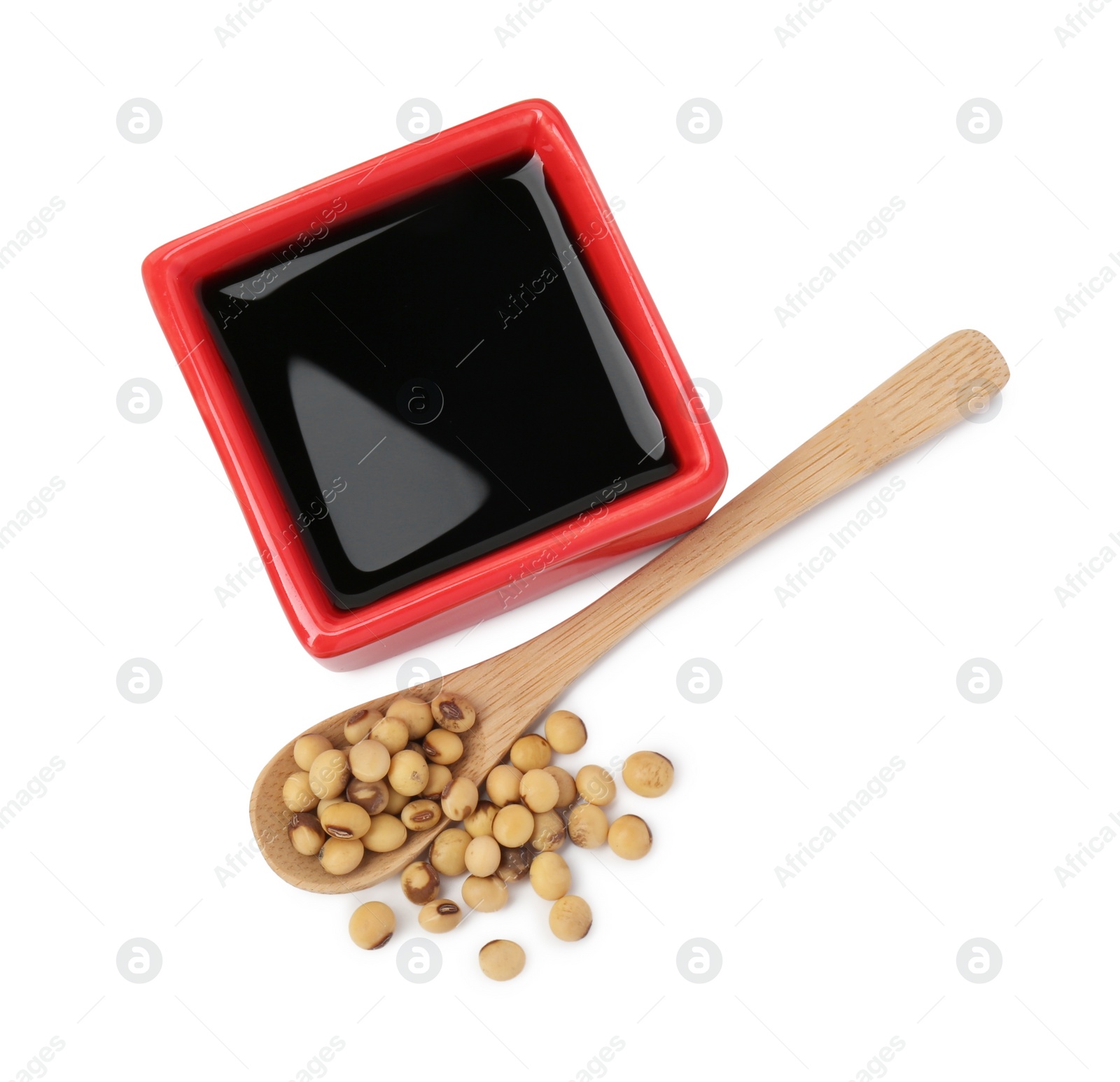 Photo of Tasty soy sauce in bowl, soybeans and spoon isolated on white, top view