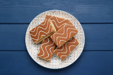 Photo of Tasty sponge cakes on blue wooden table, top view
