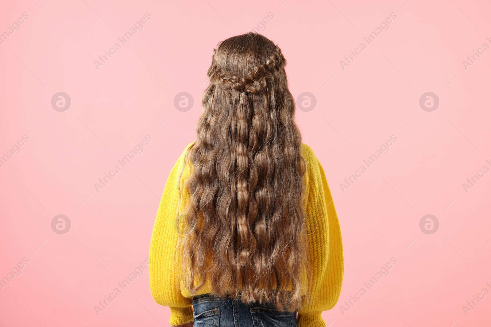 Photo of Little girl with braided hair on pink background, back view