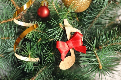 Photo of Fir tree with wooden note and decor, closeup. Christmas music concept