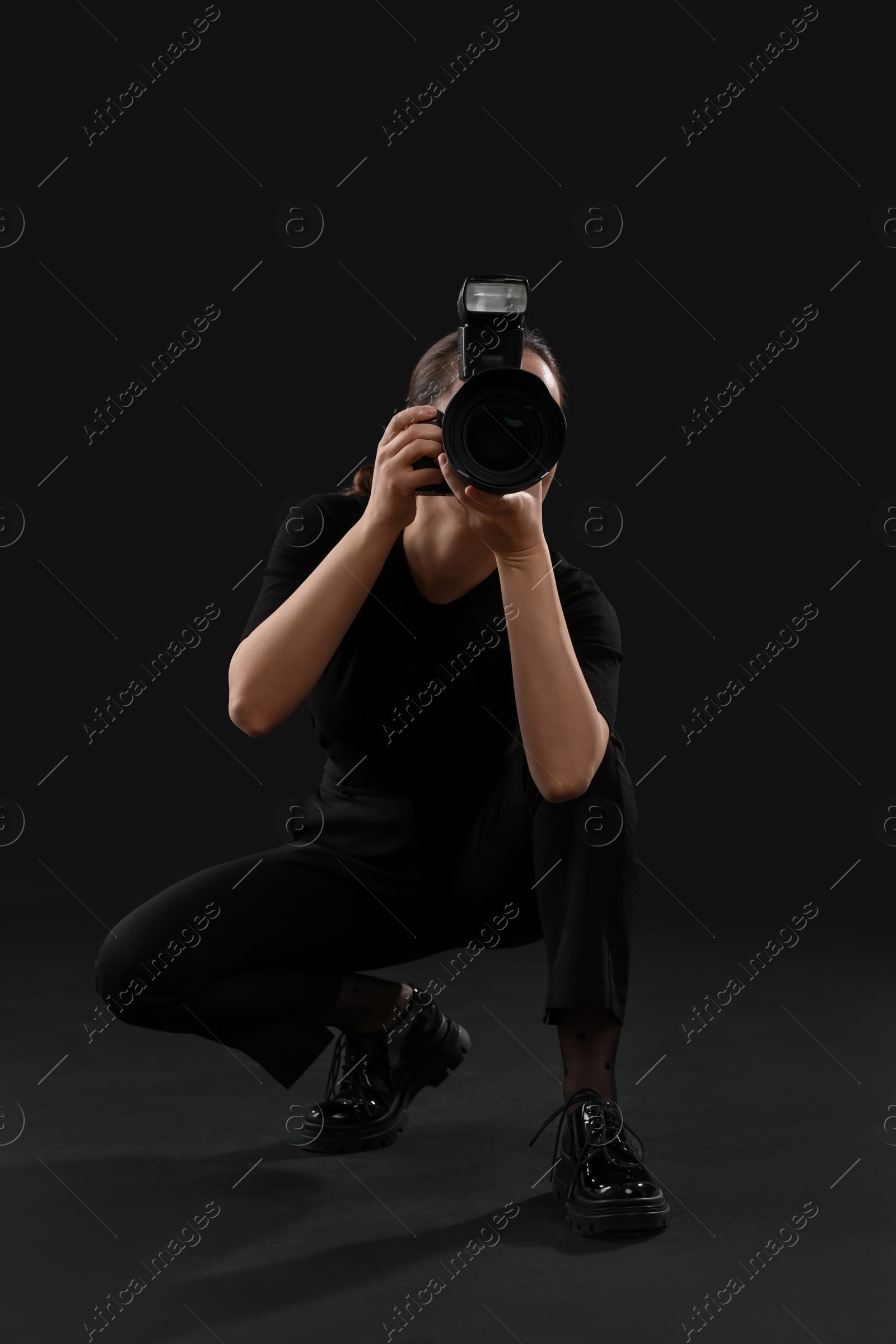 Photo of Professional photographer taking picture on black background