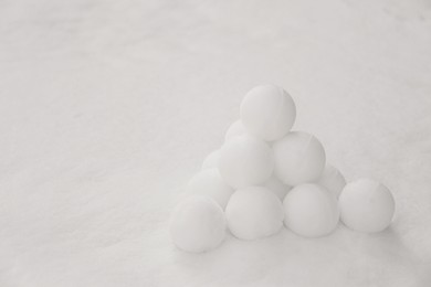 Photo of Pyramid of perfect snowballs on snow outdoors. Space for text