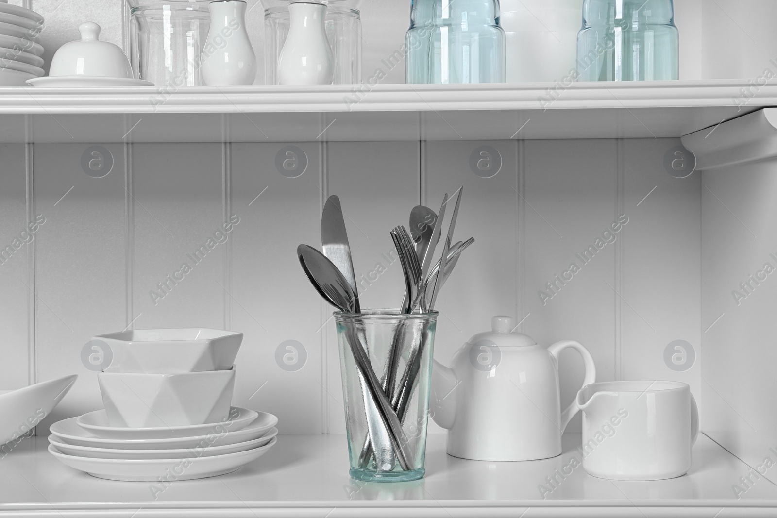 Photo of White shelving unit with set of dishware