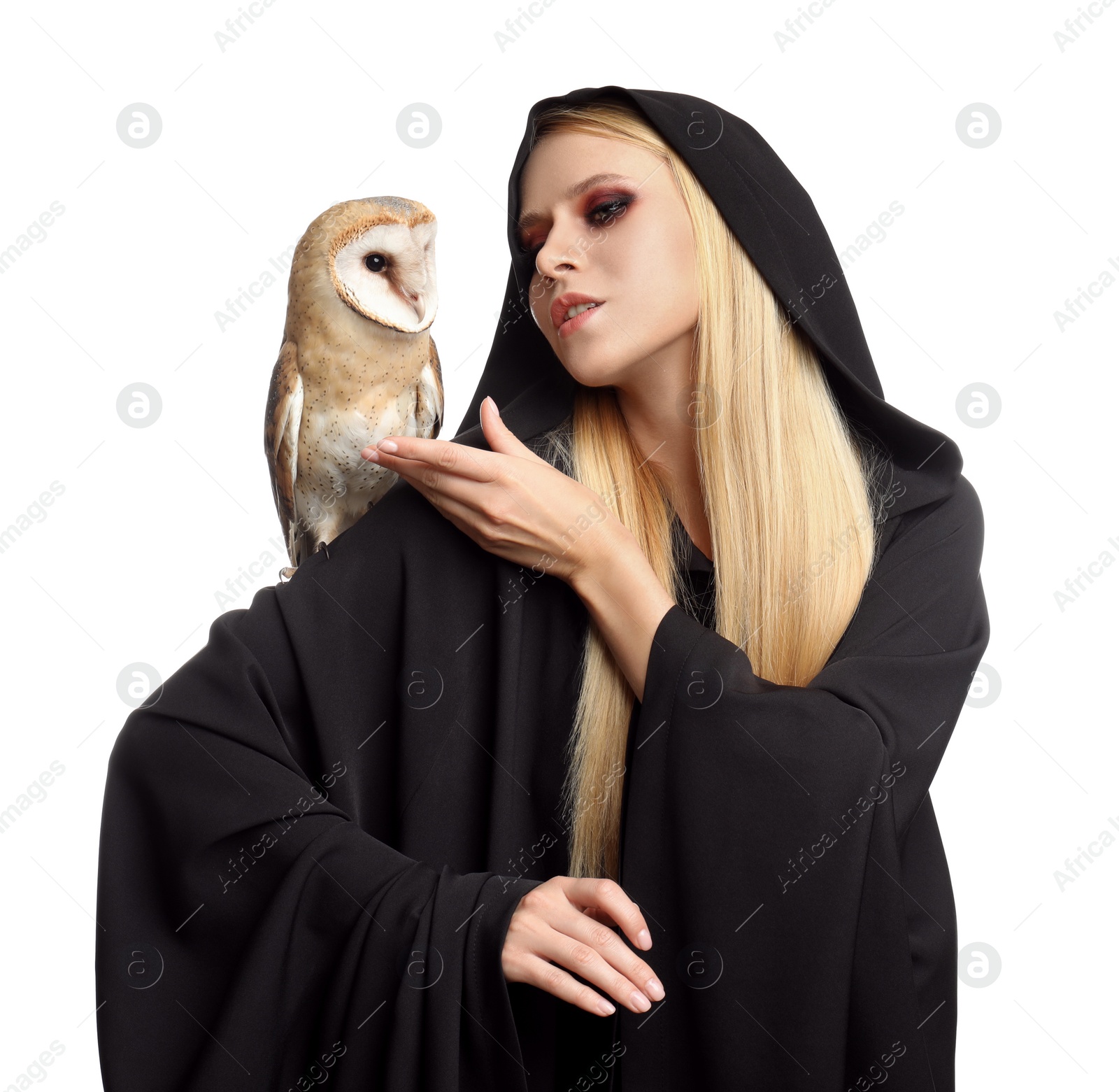 Photo of Witch in black mantle with owl isolated on white. Scary fantasy character