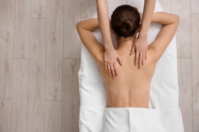 Photo of Woman receiving back massage on couch in spa salon, top view. Space for text