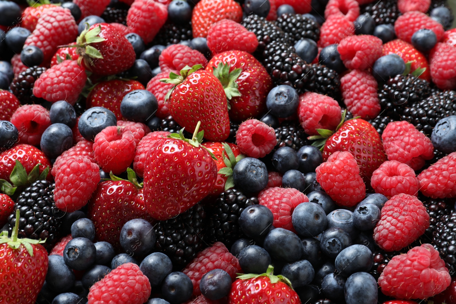 Photo of Mix of different ripe tasty berries as background, closeup view