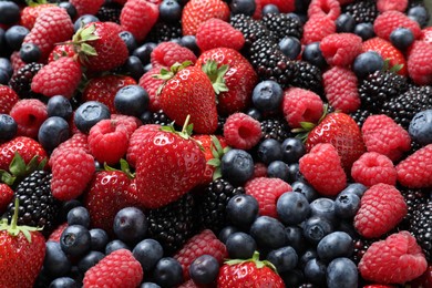 Photo of Mix of different ripe tasty berries as background, closeup view