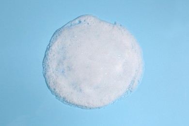 Photo of Foaming cleanser on light blue background, above view. Skin care cosmetic