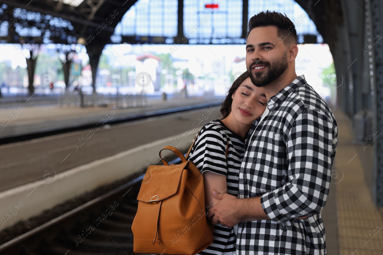 Photo of Long-distance relationship. Beautiful couple on platform of railway station, space for text