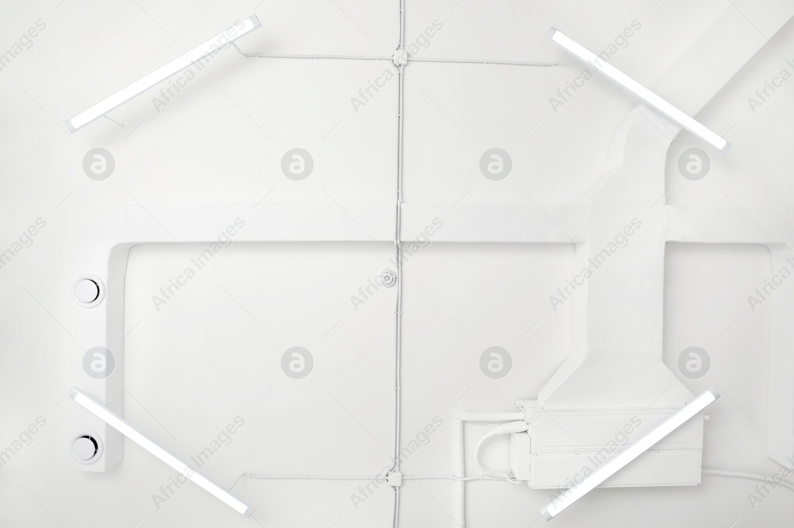 Photo of White ceiling with modern lighting in room, bottom view
