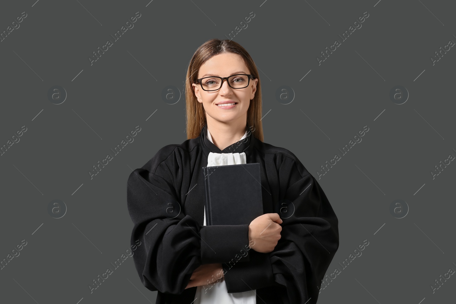 Photo of Portrait of smiling judge with book on grey background