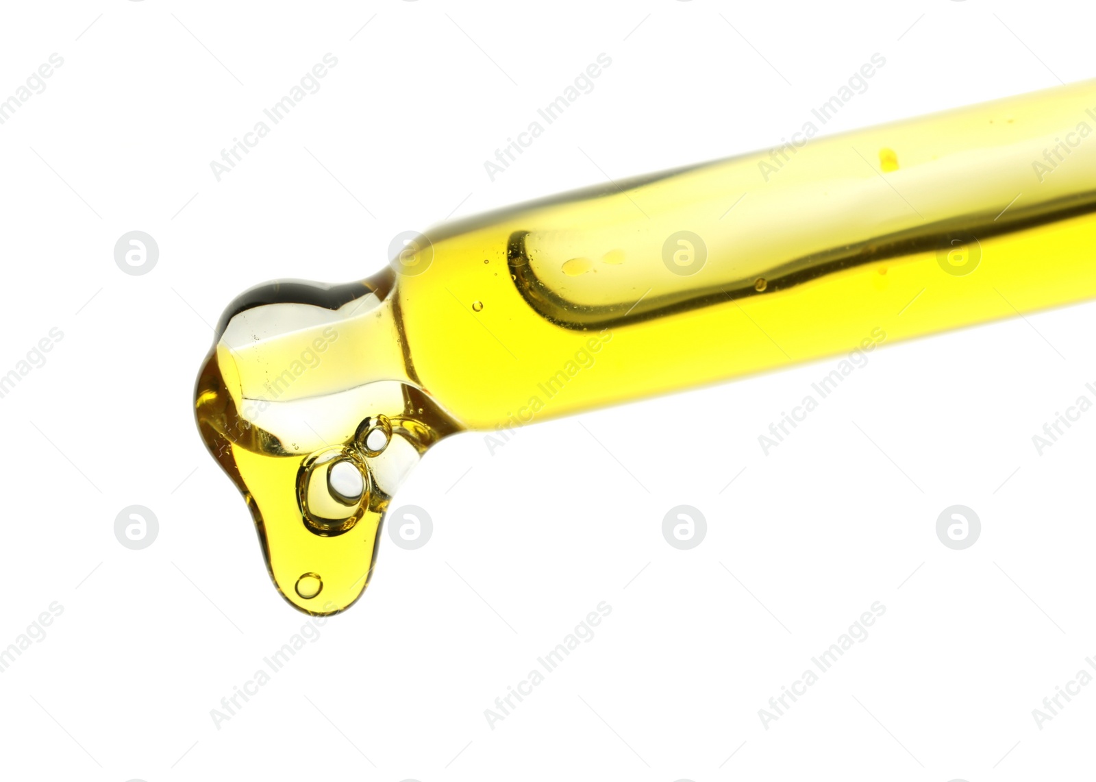 Photo of Dripping yellow facial serum from pipette on white background, closeup