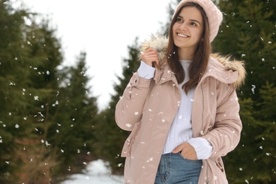 Young woman in snowy conifer forest. Winter vacation