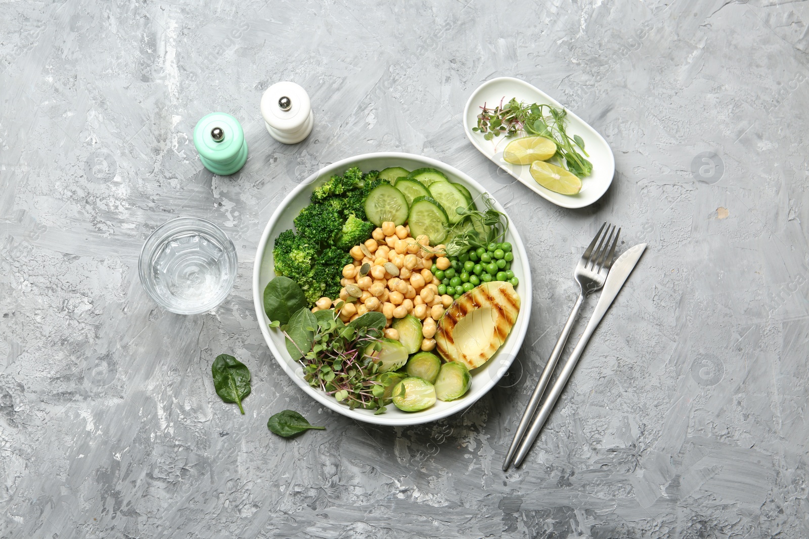 Photo of Healthy meal. Tasty vegetables and chickpeas in bowl on grey table, flat lay