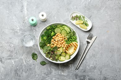 Photo of Healthy meal. Tasty vegetables and chickpeas in bowl on grey table, flat lay