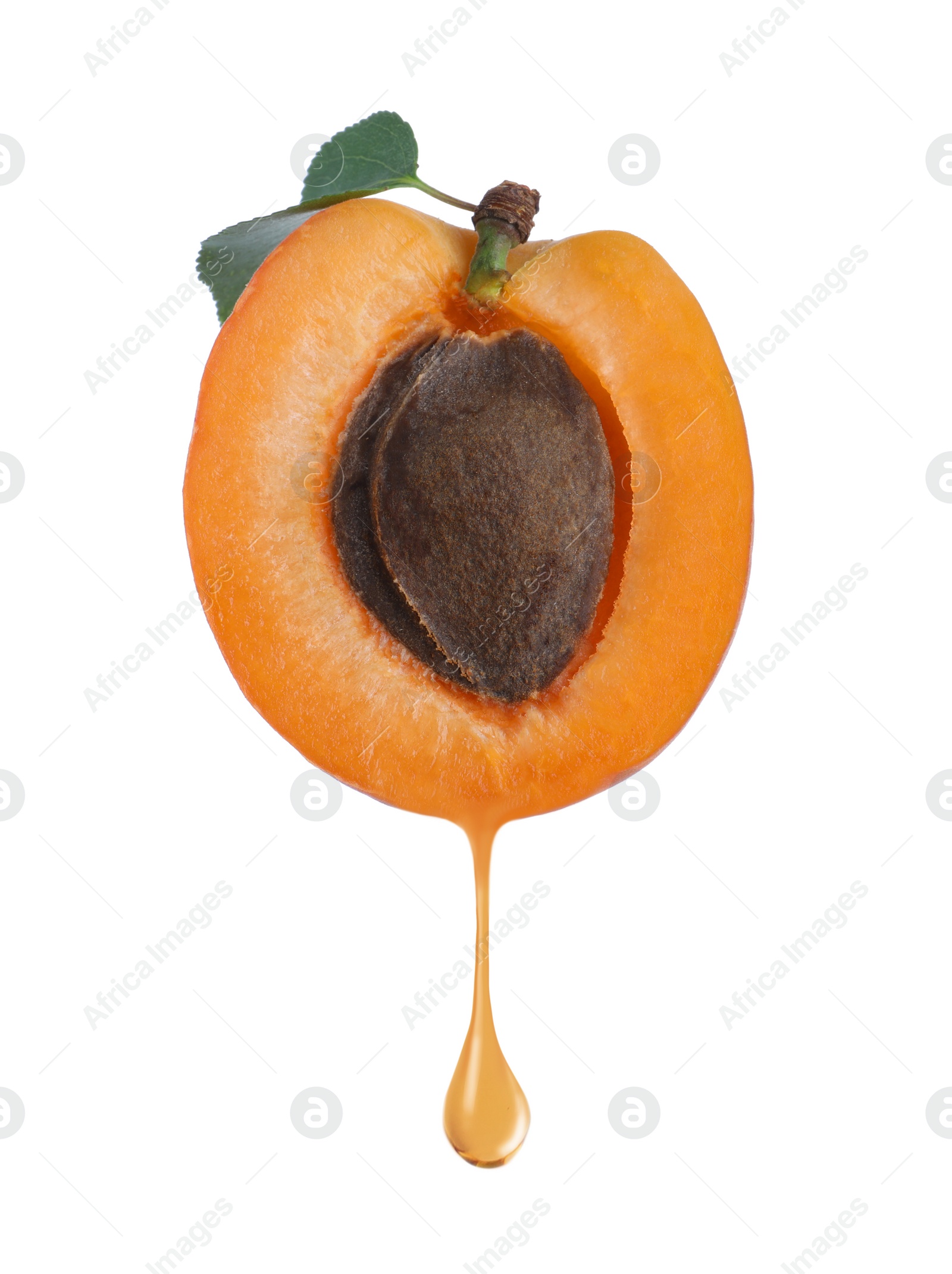 Image of Apricot kernel oil dripping from fresh fruit half on white background