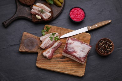 Photo of Flat lay composition of pork fatback and spices on black table