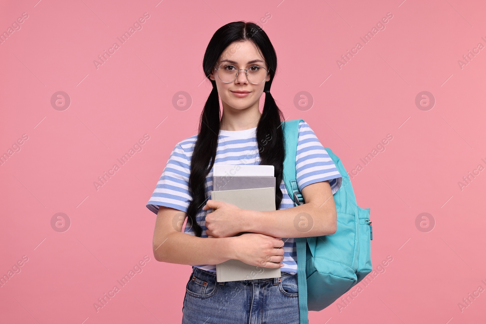Photo of Student with books and backpack on pink background