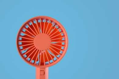 Modern electric fan on light blue background. Space for text