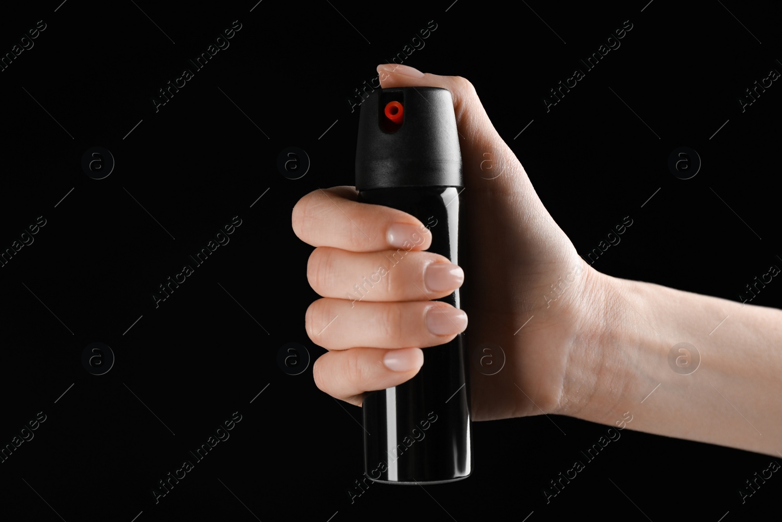 Photo of Woman holding pepper spray on black background, closeup. Space for text