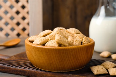 Bowl of delicious corn pads on wooden table