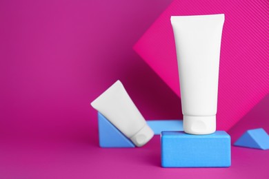 Photo of Composition with tubes of hand creams on pink background. Mockup for design