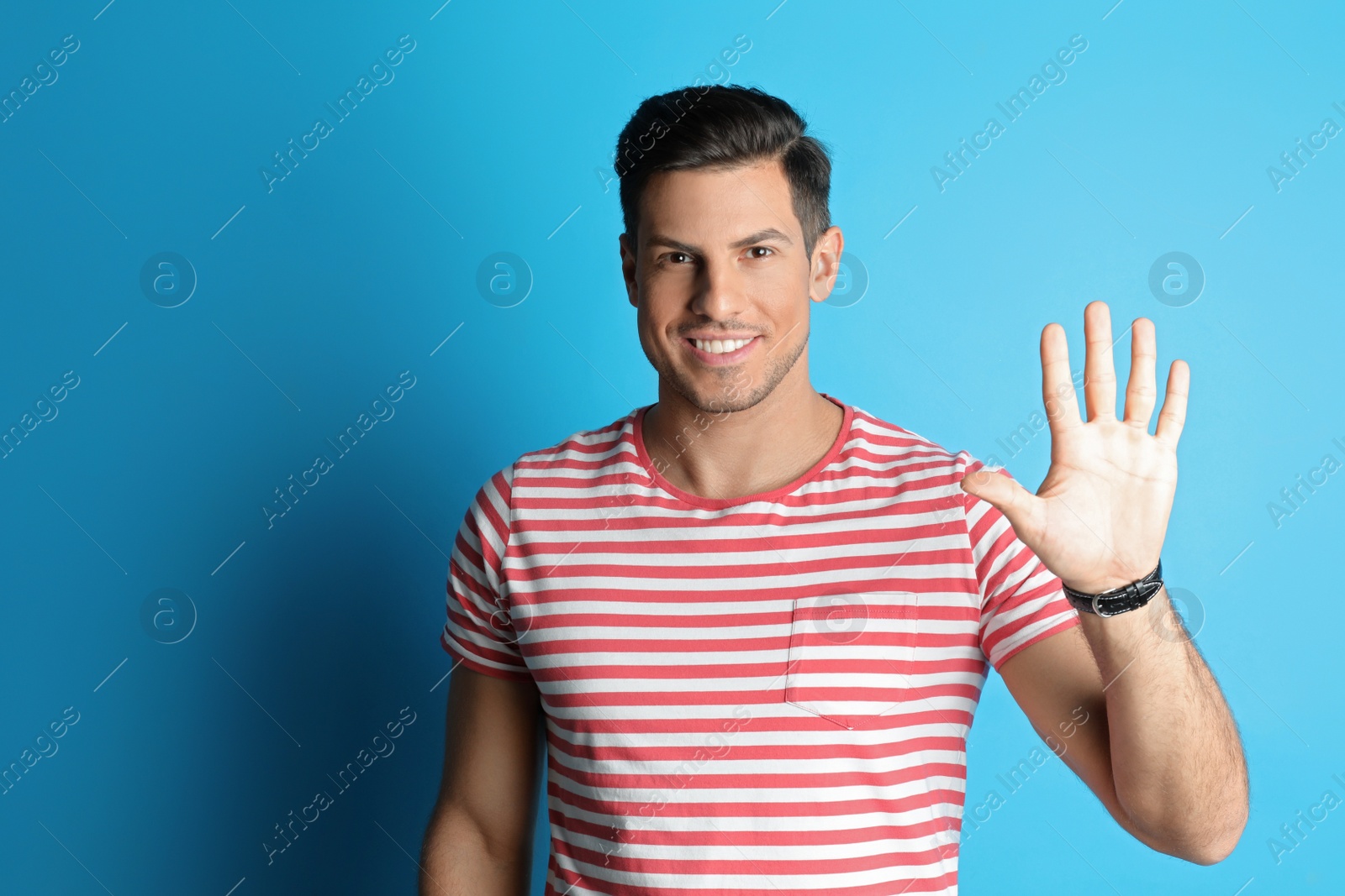 Photo of Man showing number five with his hand on light blue background