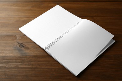 Photo of Blank paper brochure on wooden table. Mockup for design