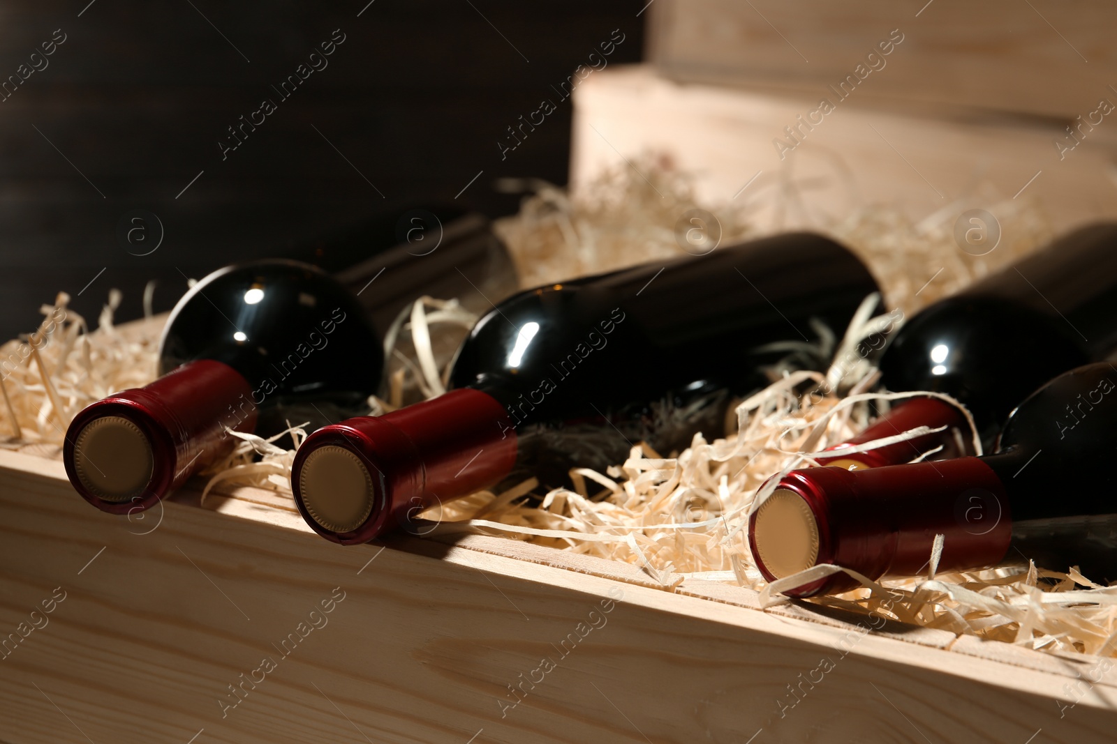 Photo of Wooden crate with bottles of wine, closeup