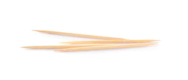 Photo of Four disposable wooden toothpicks on white background