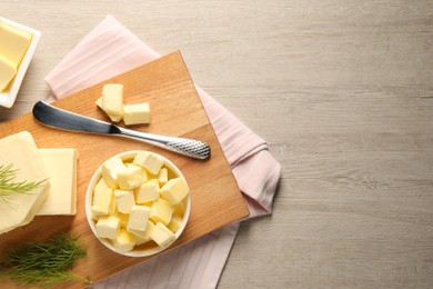 Photo of Tasty butter with dill and knife on wooden table, flat lay. Space for text