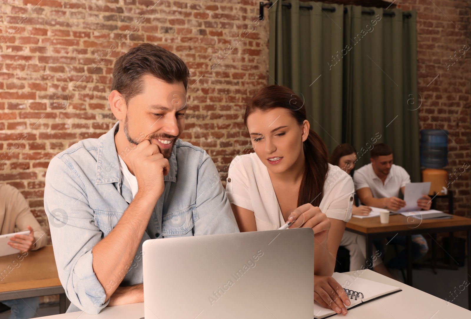 Photo of Team of employees working together in office