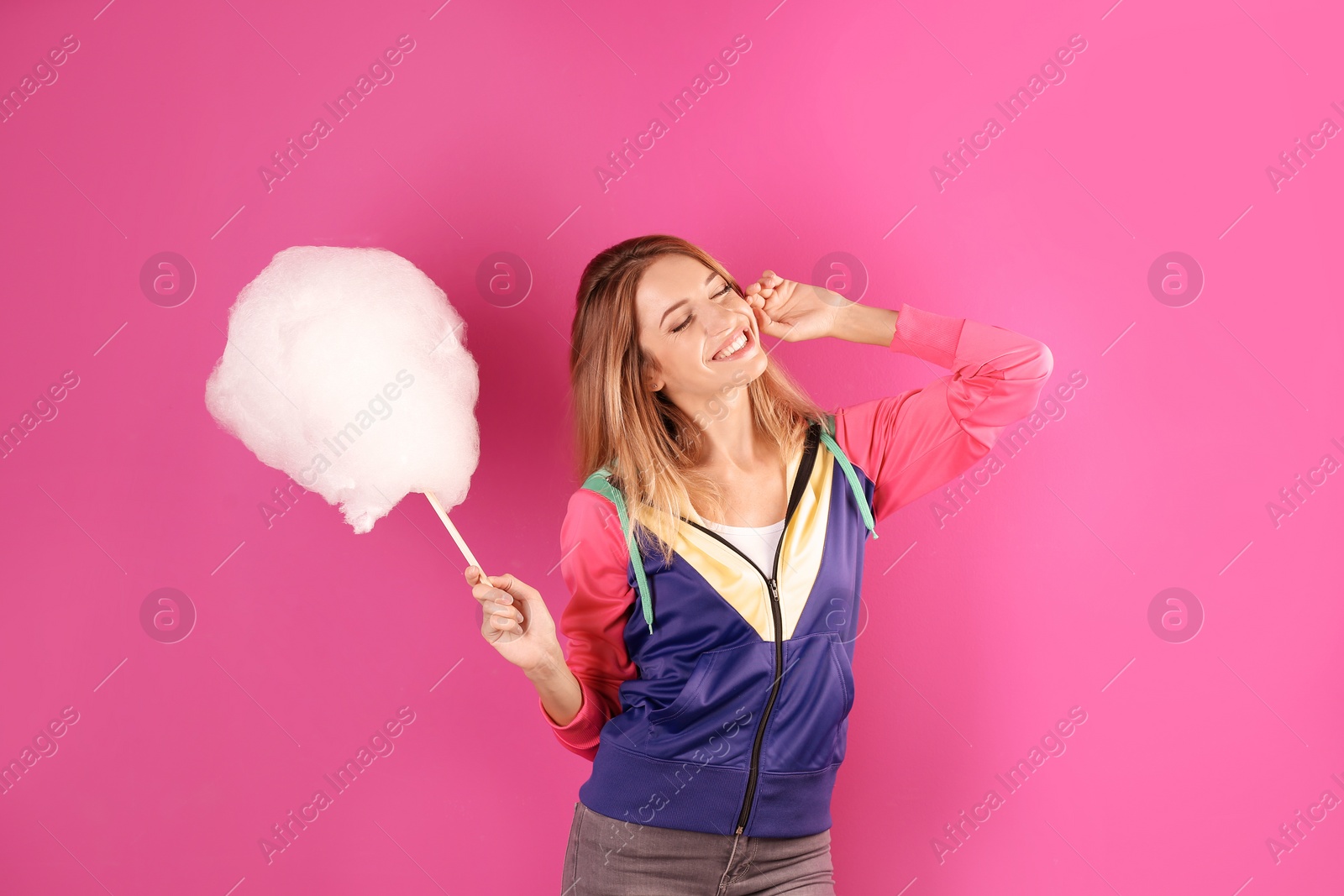 Photo of Young pretty woman with cotton candy on colorful background