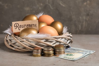 Photo of Different eggs, money and card with word Retirement on grey table. Pension concept
