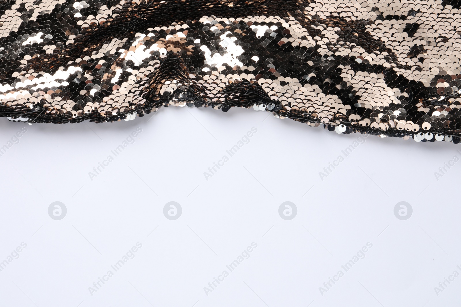 Photo of Golden shiny sequin fabric on white background. Space for text