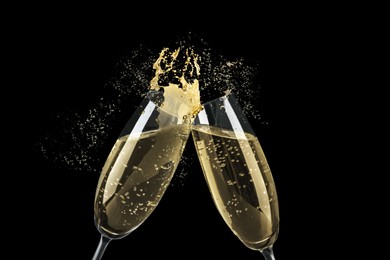 Image of Clinking glasses of sparkling wine with splash on black background