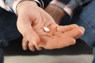 Photo of Man holding pill in hand, closeup view. Health care