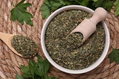 Dried aromatic parsley and fresh leaves on wicker mat, flat lay