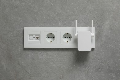 Photo of Wireless Wi-Fi repeater on light grey wall