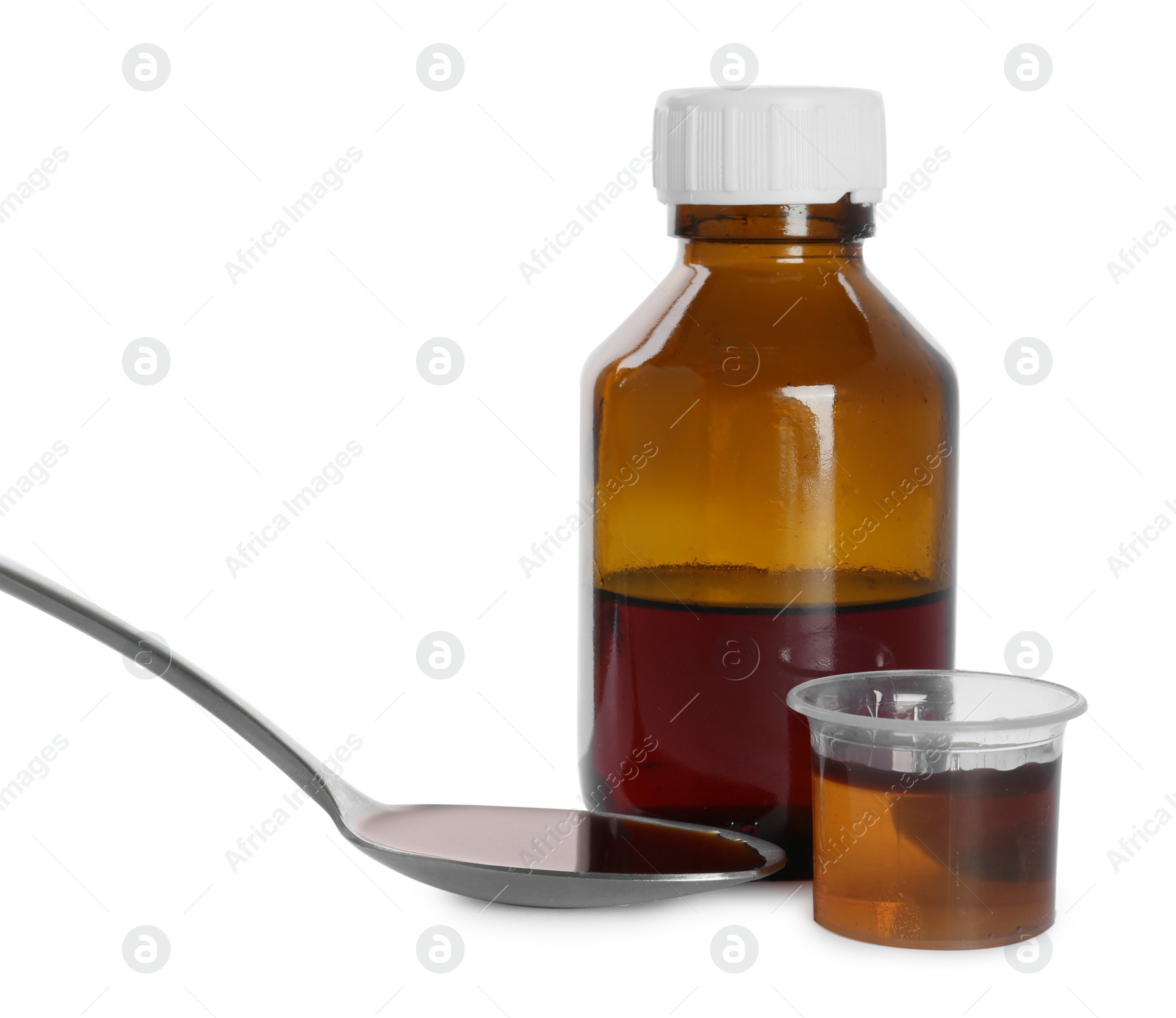 Photo of Bottle of cough syrup, spoon and measuring cup on white background
