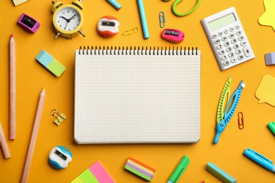 Photo of Blank notebook and school stationery on orange background, flat lay with space for text. Back to school