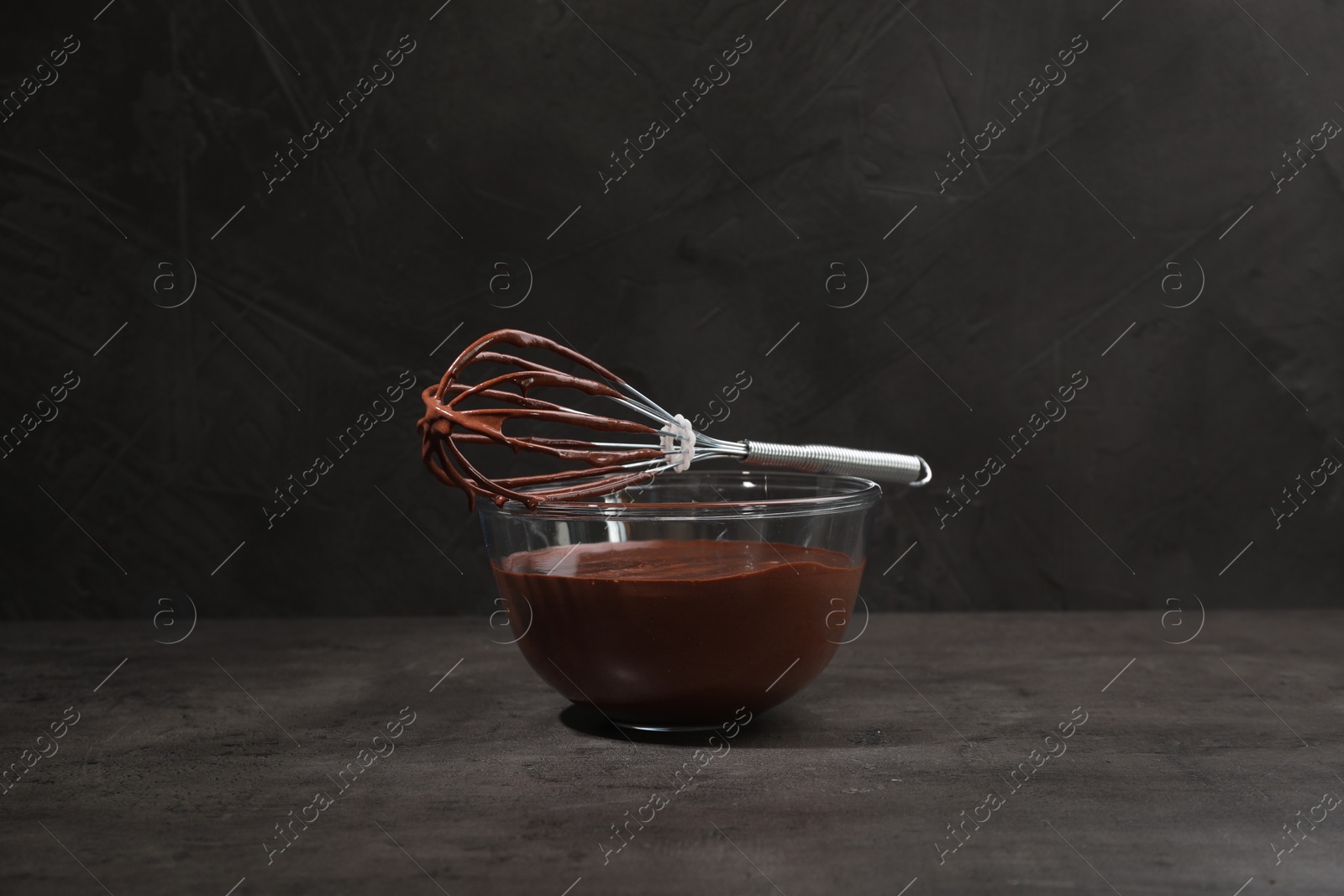 Photo of Bowl of chocolate cream and whisk on gray table