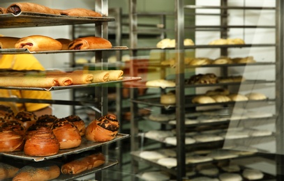 Rack with fresh pastries in bakery workshop