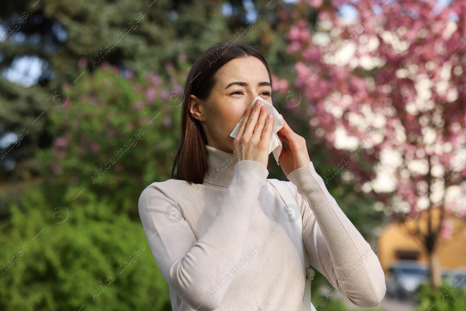 Photo of Woman with napkin suffering from seasonal allergy on spring day