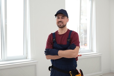 Photo of Portrait of professional construction worker with tool belt indoors