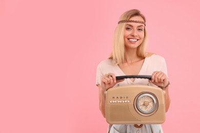 Photo of Portrait of happy hippie woman with retro radio receiver on pink background. Space for text